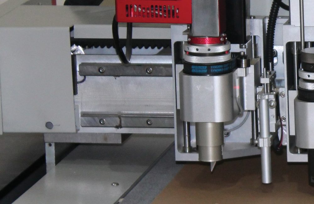 Computerised cutting and plotting table producing one-piece samples